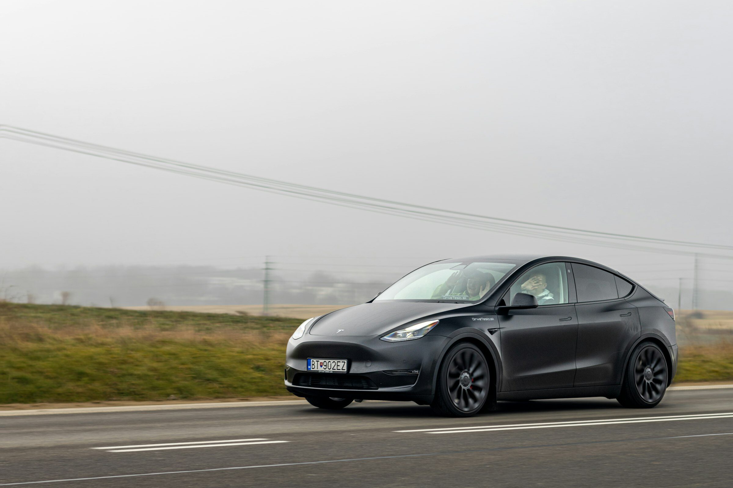 A black Tesla Model Y on an open road.